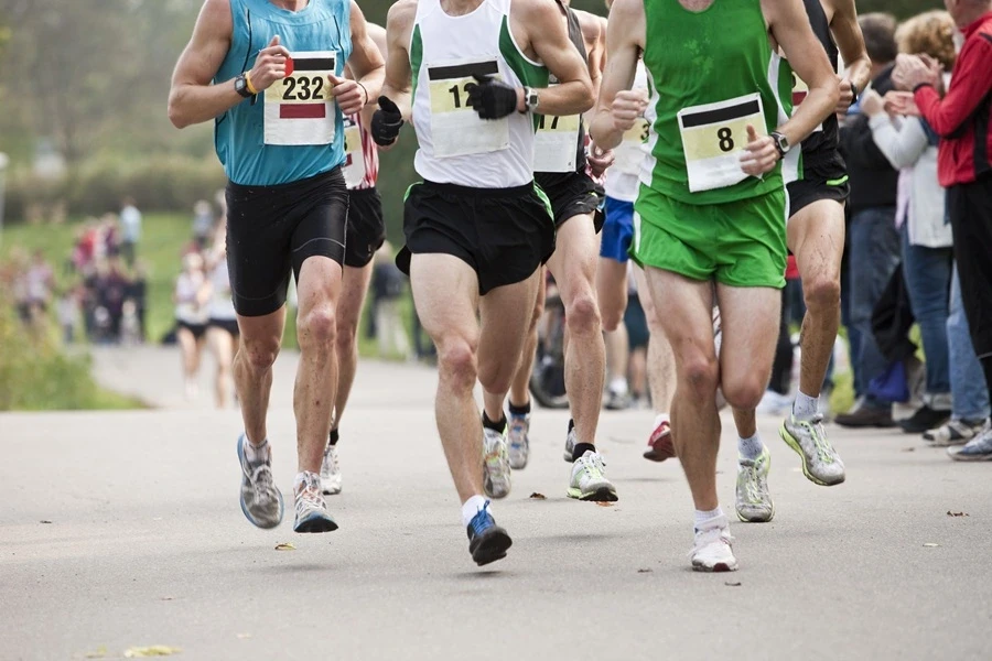 Marathon runners racing with spectators Marathon runners racing with spectators